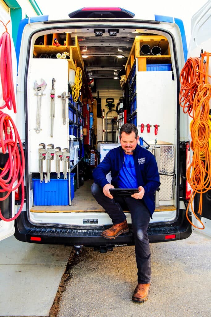 Plumbing Solutions of Idaho plumbers sitting in back of service van
