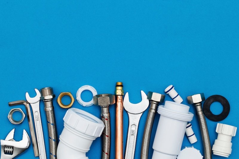 Plumbing tools and equipment overhead view on a blue background