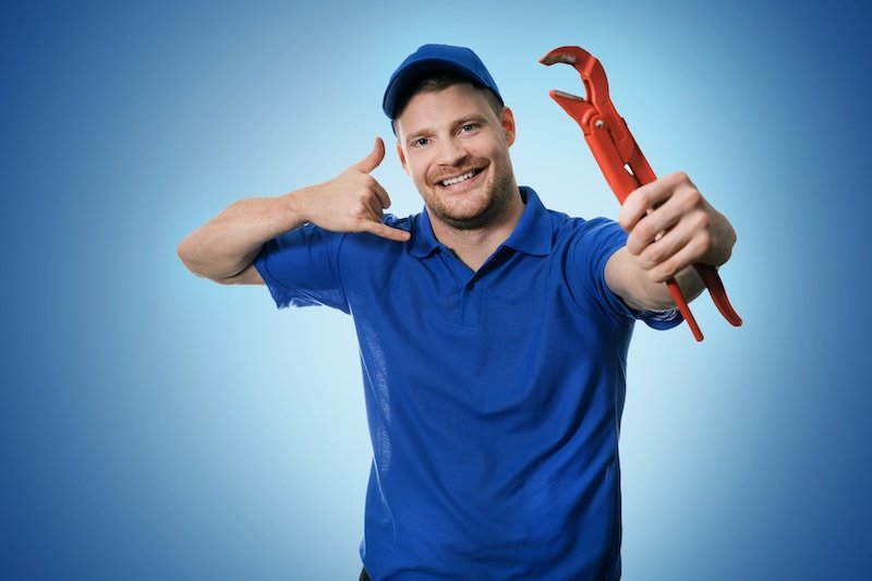 plumbing services - plumber with wrench showing phone call gesture on blue background Call Meridian plumber
