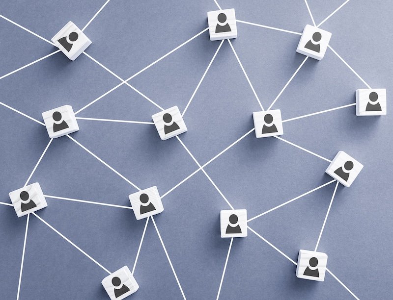 Wooden blocks connected together on blue background. Teamwork, network and community concept.