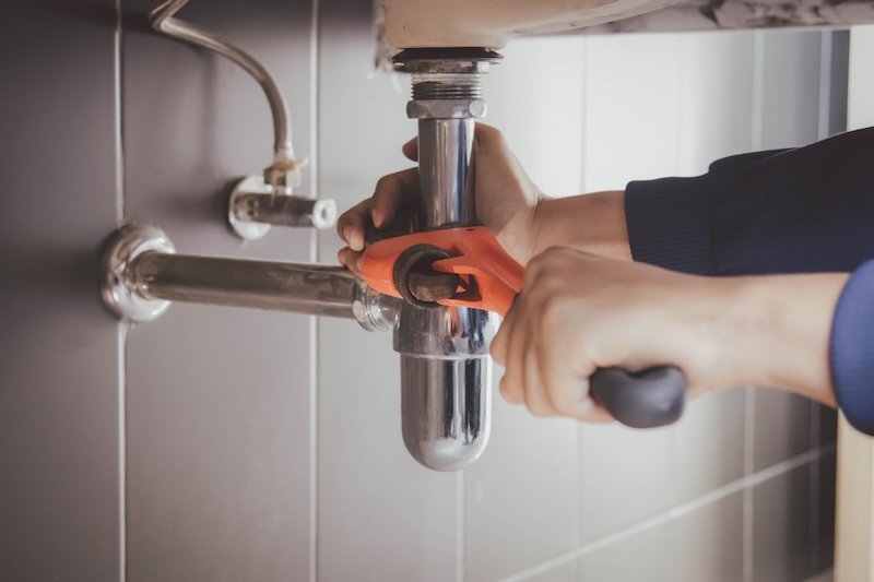 plumber at work in a bathroom, plumbing repair service , fix water plumbing leaks, replace the kitchen sink drain plumbing maintenance