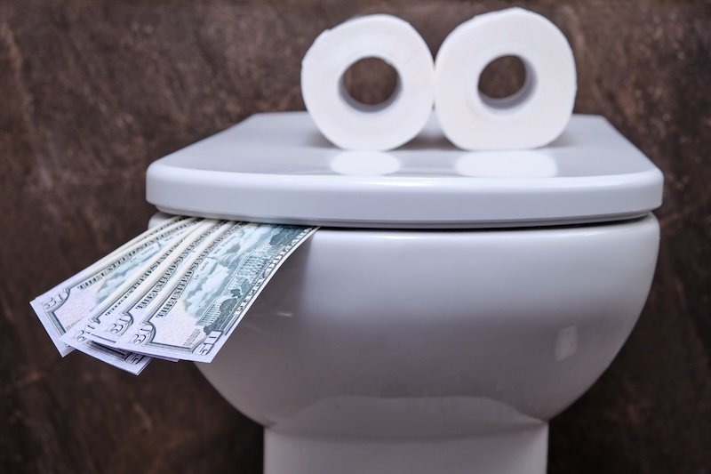 Concept of a fun toilet with a tongue made of us dollars and an eye toilet paper meridian plumbing