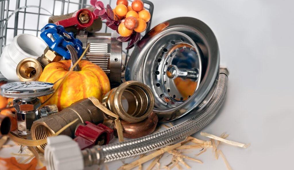 Plumbing tools with small pumpkins and festive Thanksgiving elements. Holiday season home maintenance concept.