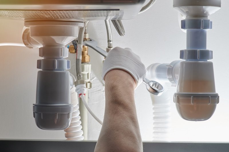 Installing drain system in kitchen close up view