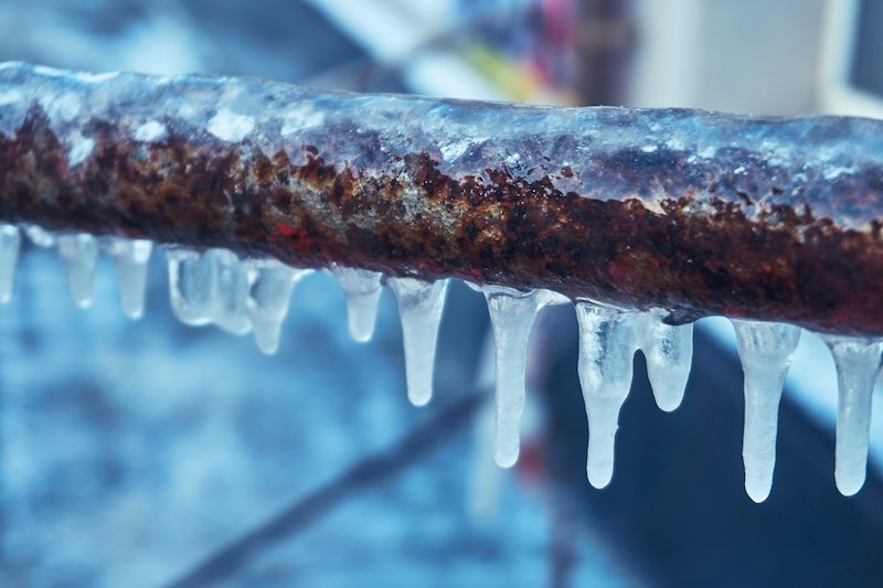 meridian plumbing Many small icicles have frozen on a rusty pipe in the street in the winter